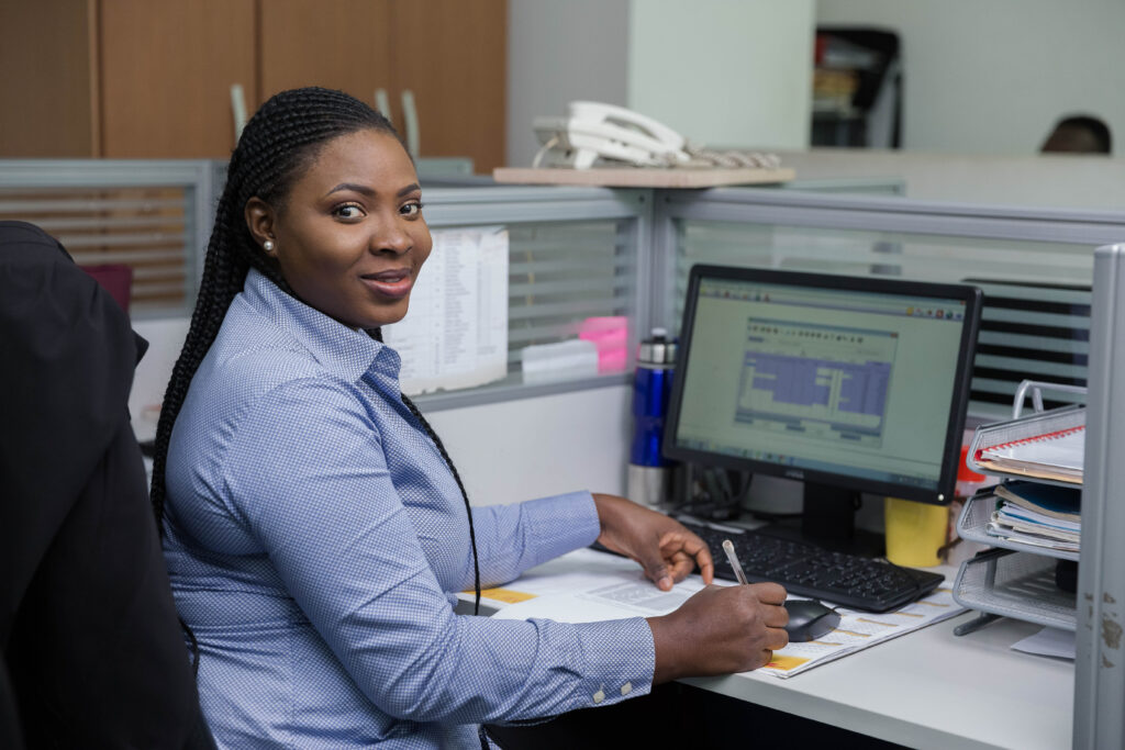 Woman looking at the camera in front of computer